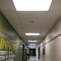 Bright LED ceiling panels installed in a hallway using LED Magnetic Retrofit Kit for 2x2 Parabolic Troffer 5-CCT