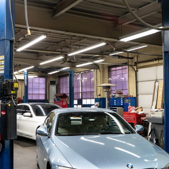 8ft LED Tube 40W FA8 Type B installed in a bright auto repair shop illuminating work areas efficiently