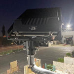 LUX LED Flood Light mounted outdoors illuminating a parking area with energy-efficient bright lighting at night