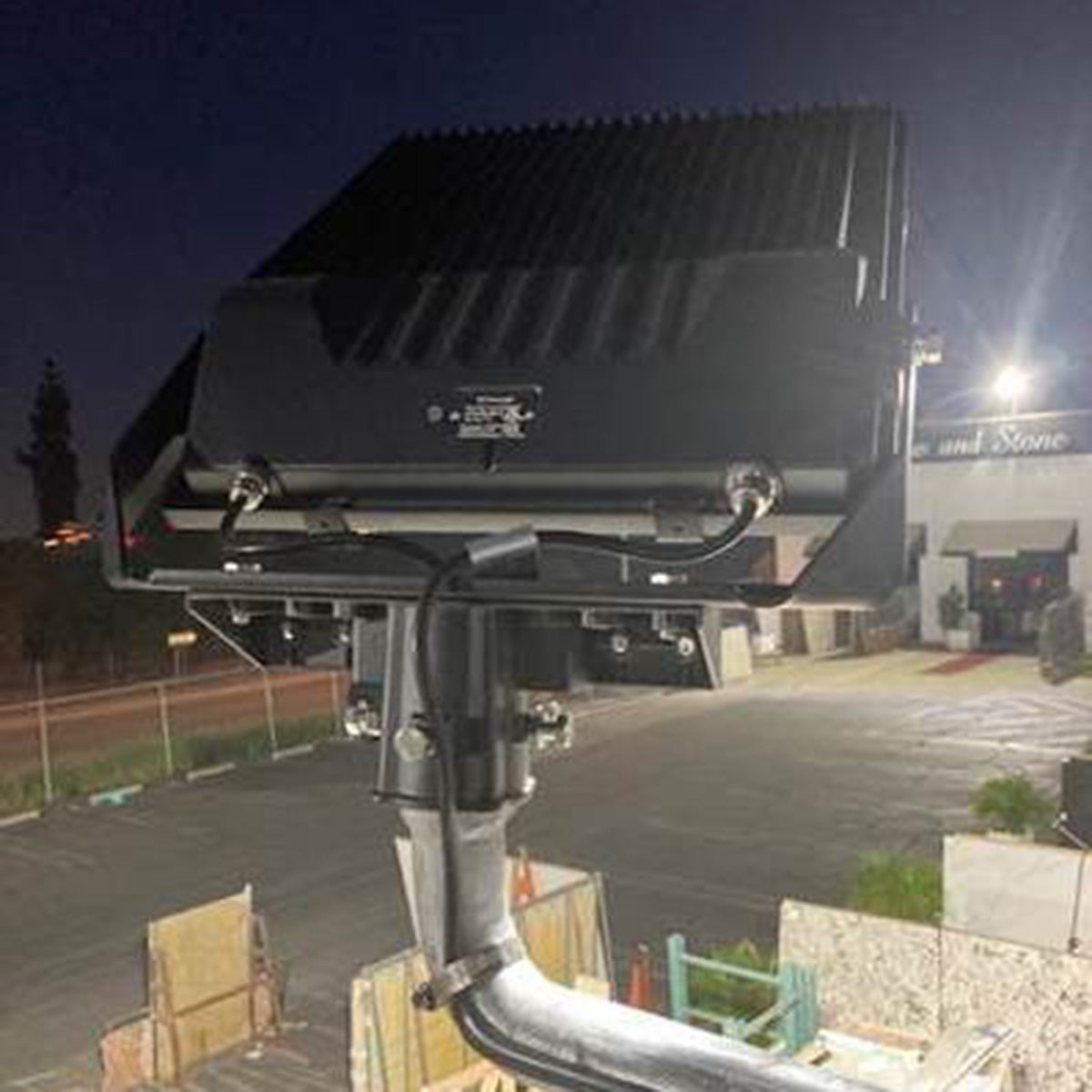 LUX LED Flood Light mounted outdoors illuminating a parking area with energy-efficient bright lighting at night
