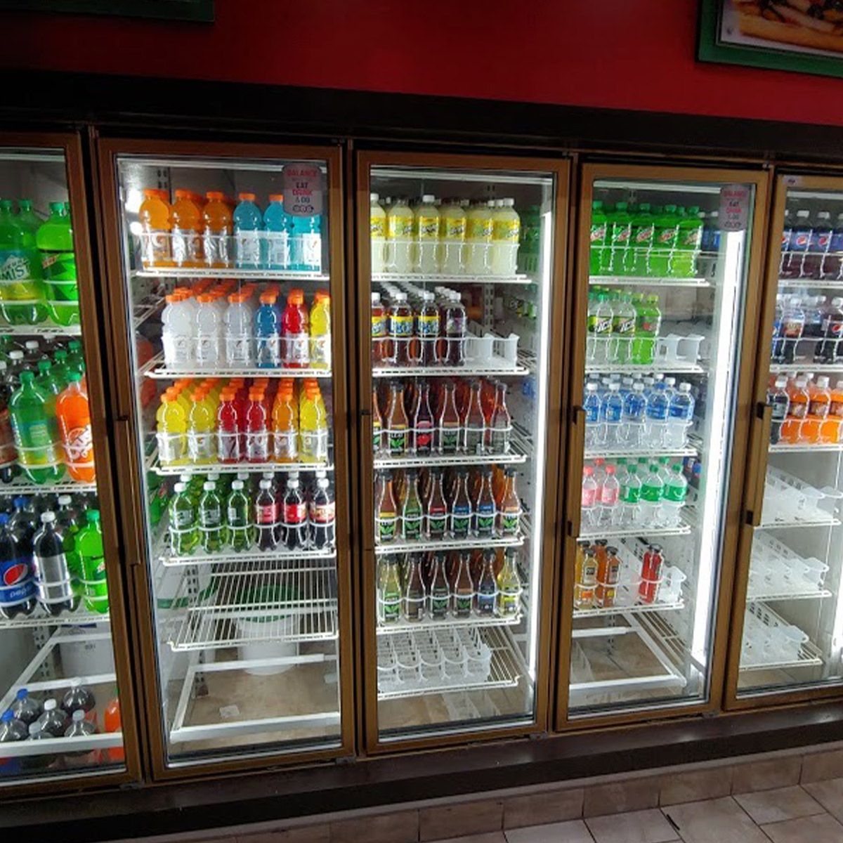 Refrigerated display cases with bright 5ft Cooler/Freezer LED Tube 25W lighting showcasing assorted beverages inside.