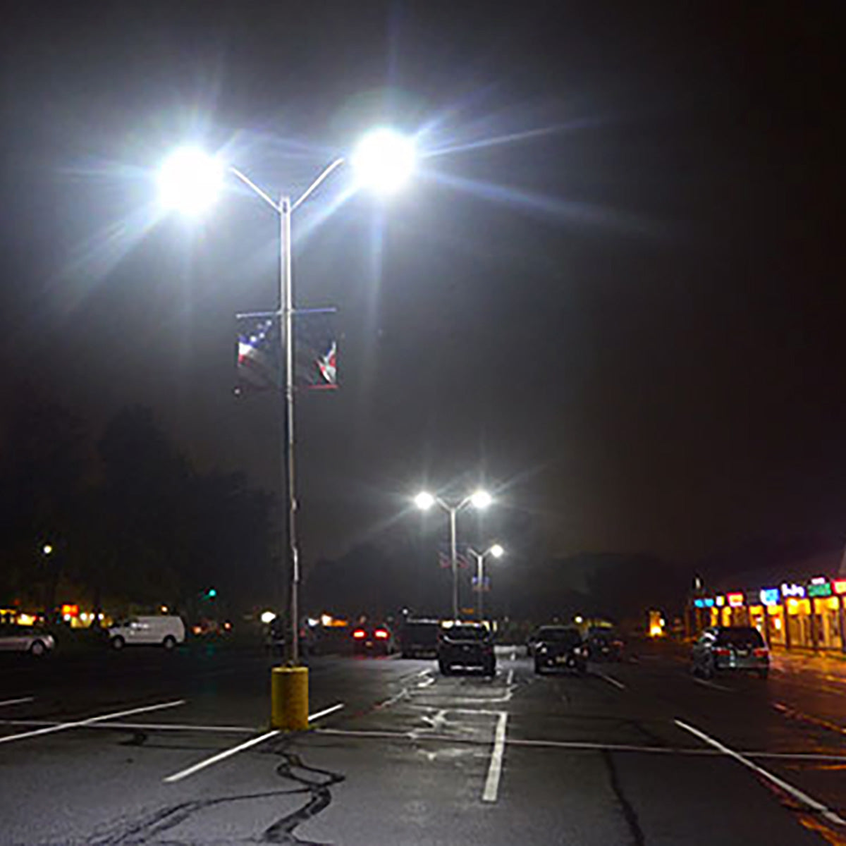 LED Shoebox & Wall Pack Retrofit 3 CCT 50W illuminating parking lot with bright, unidirectional light at night.