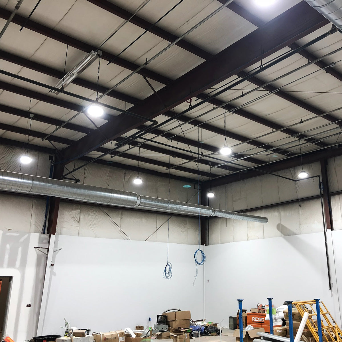 UFO LED High Bay lights installed in warehouse with adjustable beam angles and bright white illumination