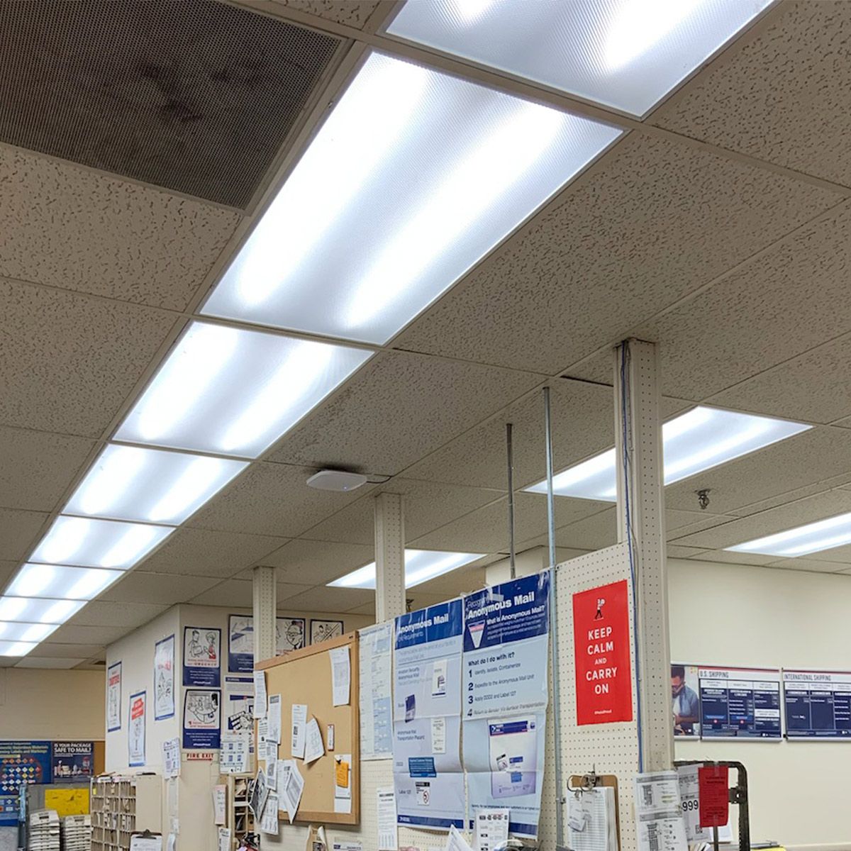 Four-foot LED linear retrofit strips with magnetic mounting installed in warehouse ceiling replacing fluorescent fixtures showing high lumen output and wide distribution pattern for industrial applications